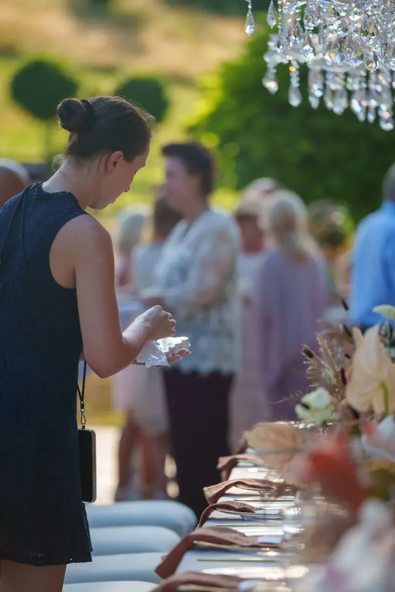 Gästin bei festlich gedeckter Tafel in warmem Abendlicht