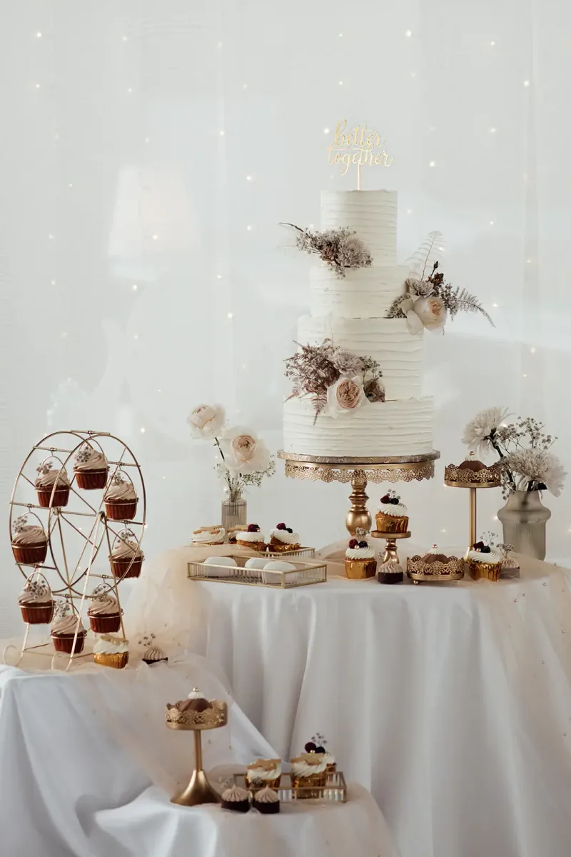 Mehrstöckige Hochzeitstorte mit goldener Topper-Schrift
