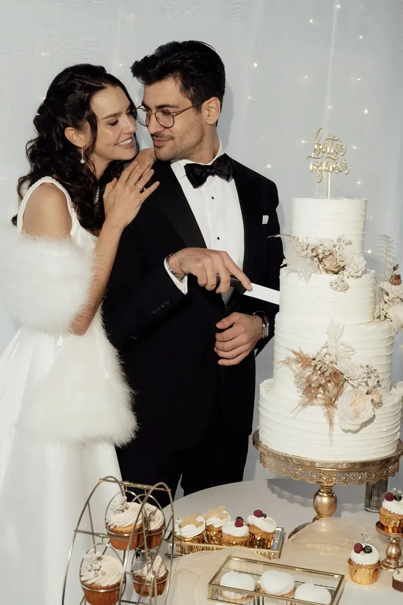 Brautpaar schneidet gemeinsam die Hochzeitstorte an