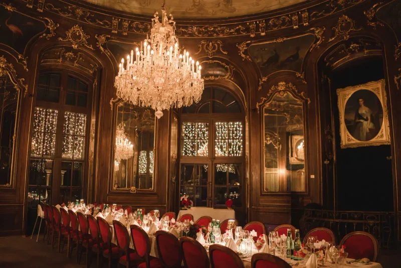 Prunkvoller dunkler Bankettsaal mit lang gedeckter Tafel